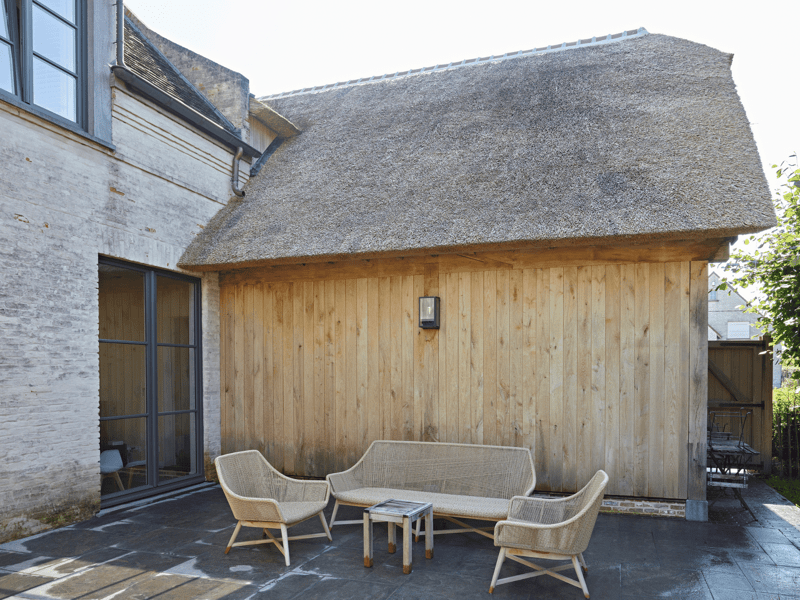 Dubbele carport aanbouw met rieten dak en bovenverdieping