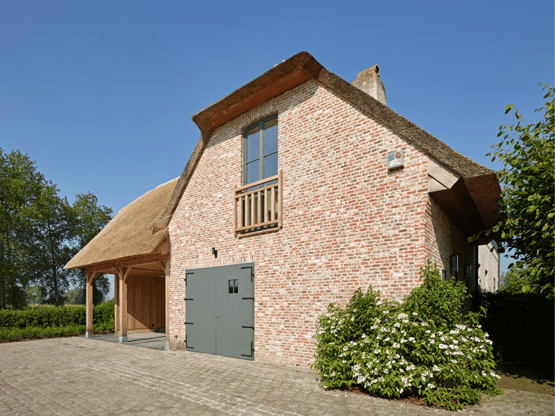 Dubbele carport aanbouw met rieten dak en bovenverdieping